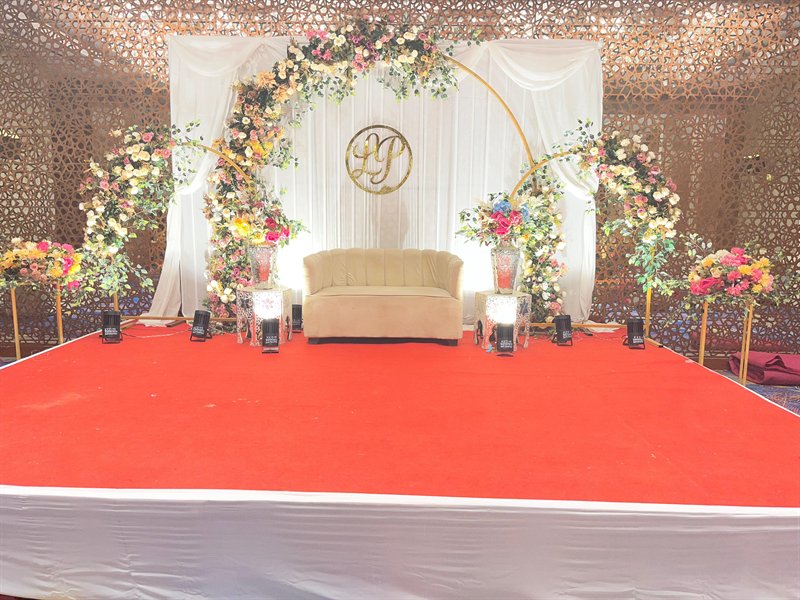 Draped engagement stage with gold hoops and monogram installation in Jaipur by Shava Moments