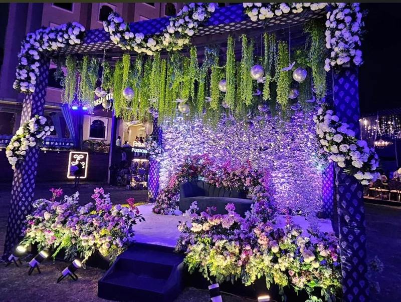 Four-post canopy sangeet stage with hanging greenery and floral base in Jaipur by Shava Moments