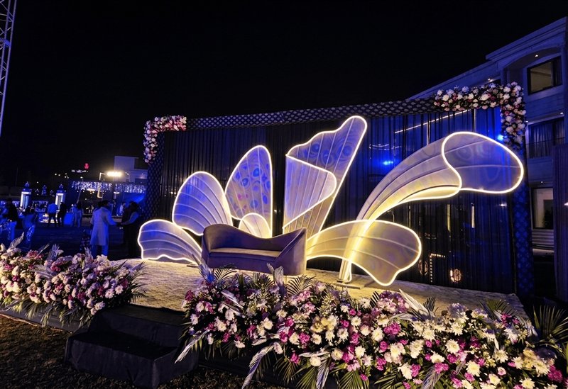 Illuminated petal sculpture sangeet stage at night in Jaipur by Shava Moments
