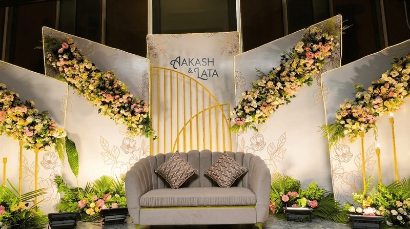 Angled panel wedding stage with sweeping floral garlands and gold arch in Jaipur by Shava Moments